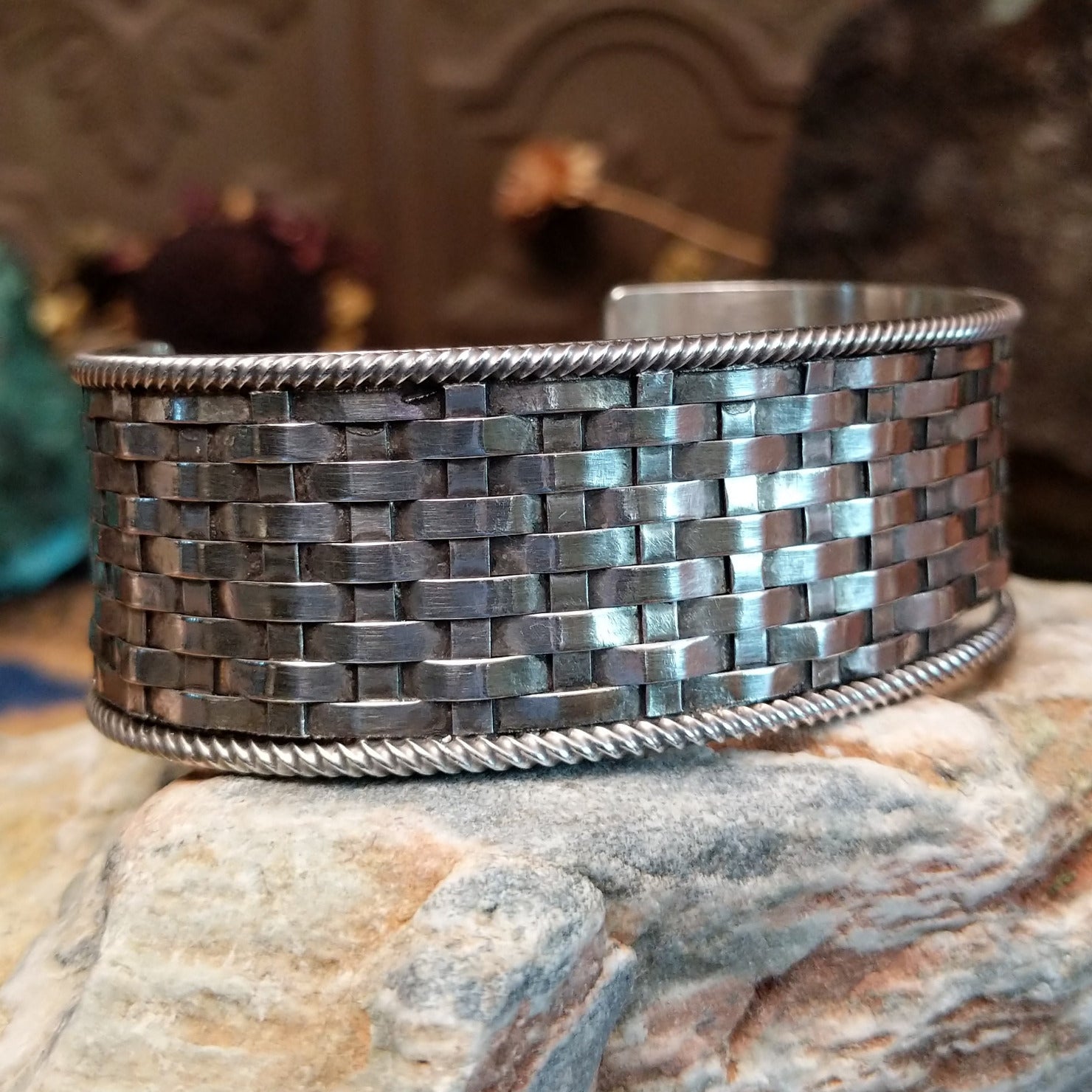 Wide sterling silver cuff bracelet with a woven basketweave pattern and twisted rope borders.