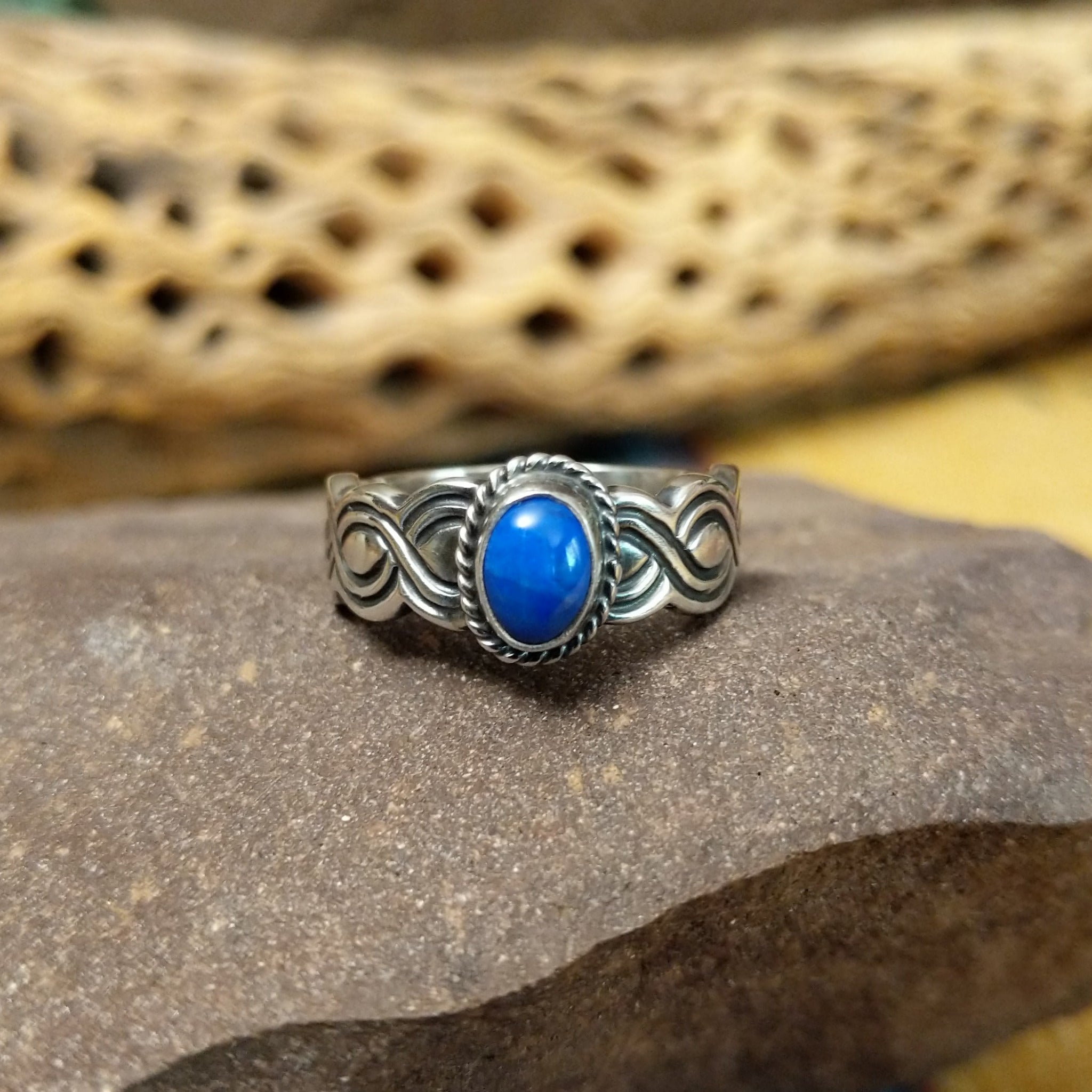 Lapis ring with weaving band by Raymond Coriz, featuring a deep blue lapis stone with natural pyrite flecks set in a handcrafted sterling silver woven band.