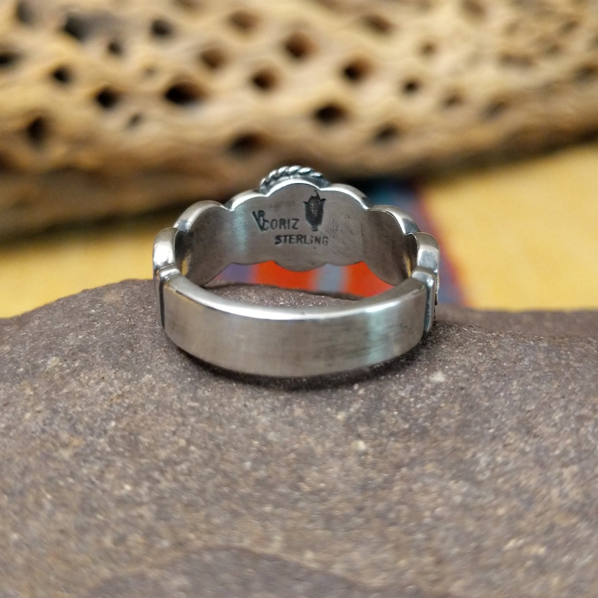 Lapis ring with weaving band by Raymond Coriz, featuring a deep blue lapis stone with natural pyrite flecks set in a handcrafted sterling silver woven band. Underside view.