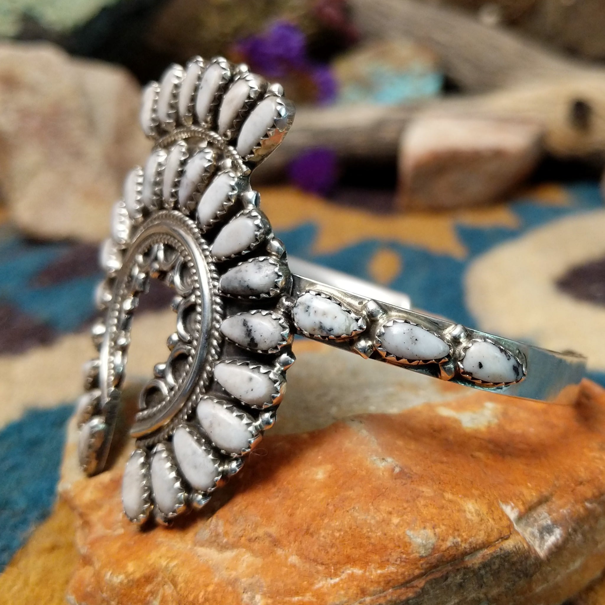 Handcrafted sterling silver Naja cuff by Zeta Begay featuring White Buffalo stones in a fan pattern with twisted rope detailing, silver bead accents, and traditional Navajo craftsmanship; side view.