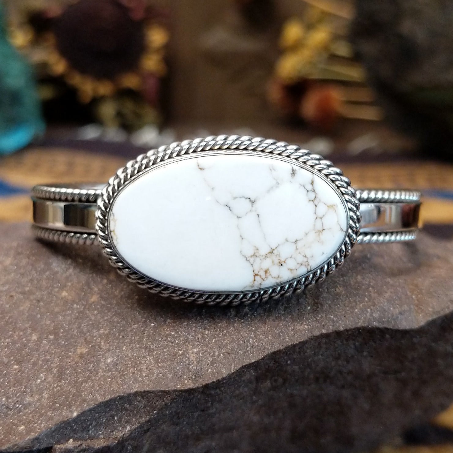Sterling silver cuff featuring a White Buffalo stone set in a twisted rope bezel.