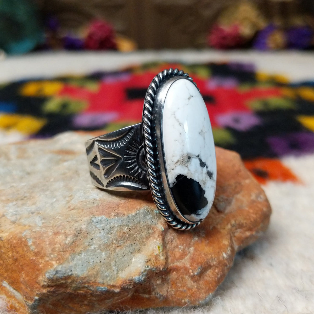 White Buffalo Oval Ring by Angel Martin & Bernyse Chavez with a large black-and-white stone set in a twisted rope-style sterling silver frame; side view.