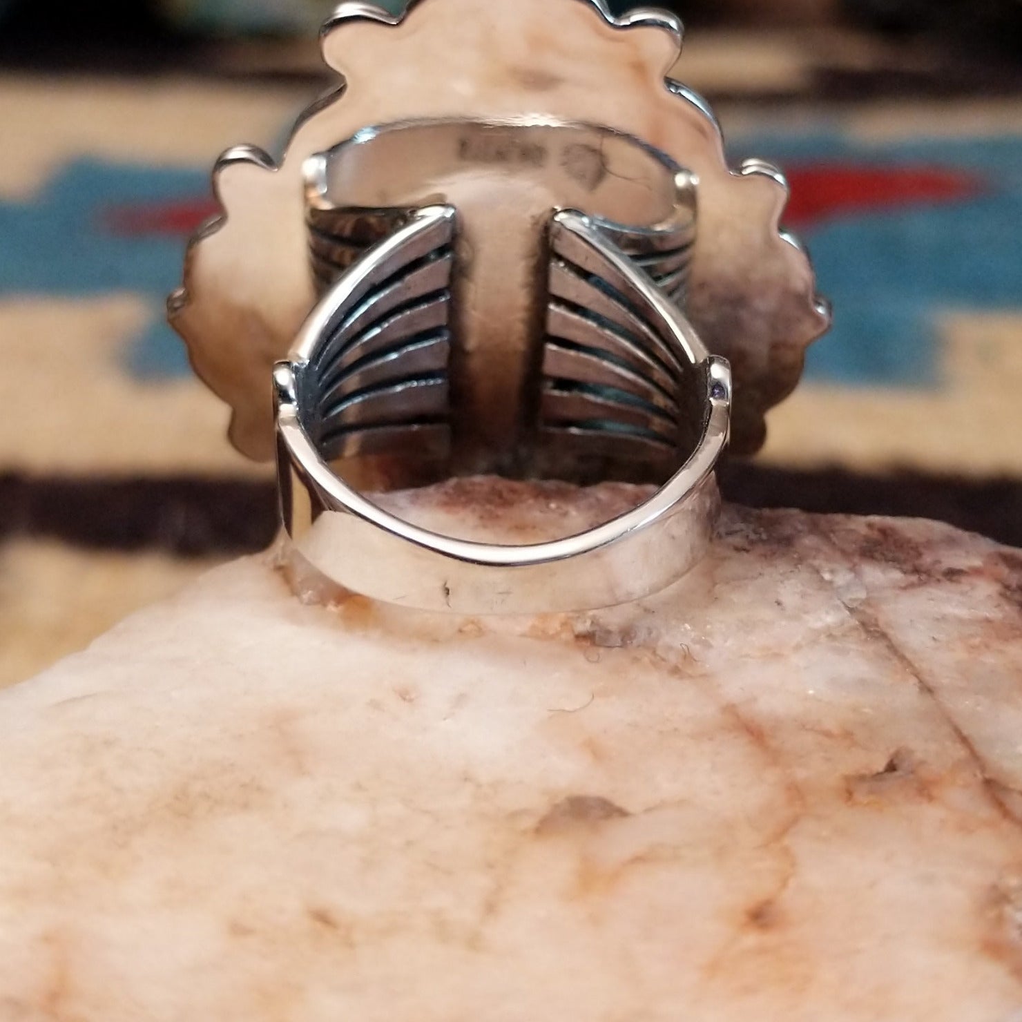 Sterling silver ring features white buffalo set in oval bezel with filigree pattern.