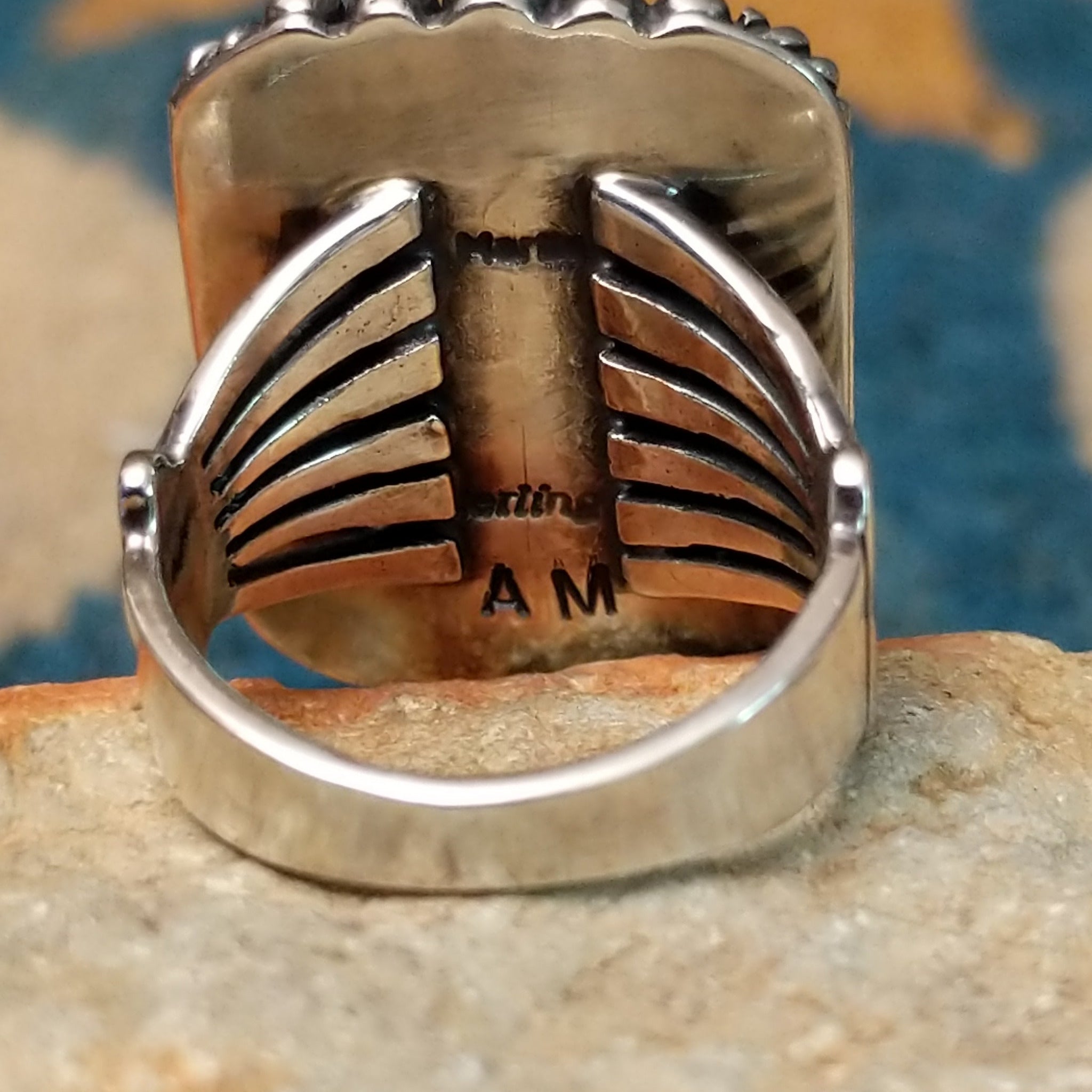 Handcrafted sterling silver White Buffalo ring by Alfred Martinez, featuring a rectangular White Buffalo gemstone with a twisted rope border and silver bead accents; artisan and Sterling Silver stamp.