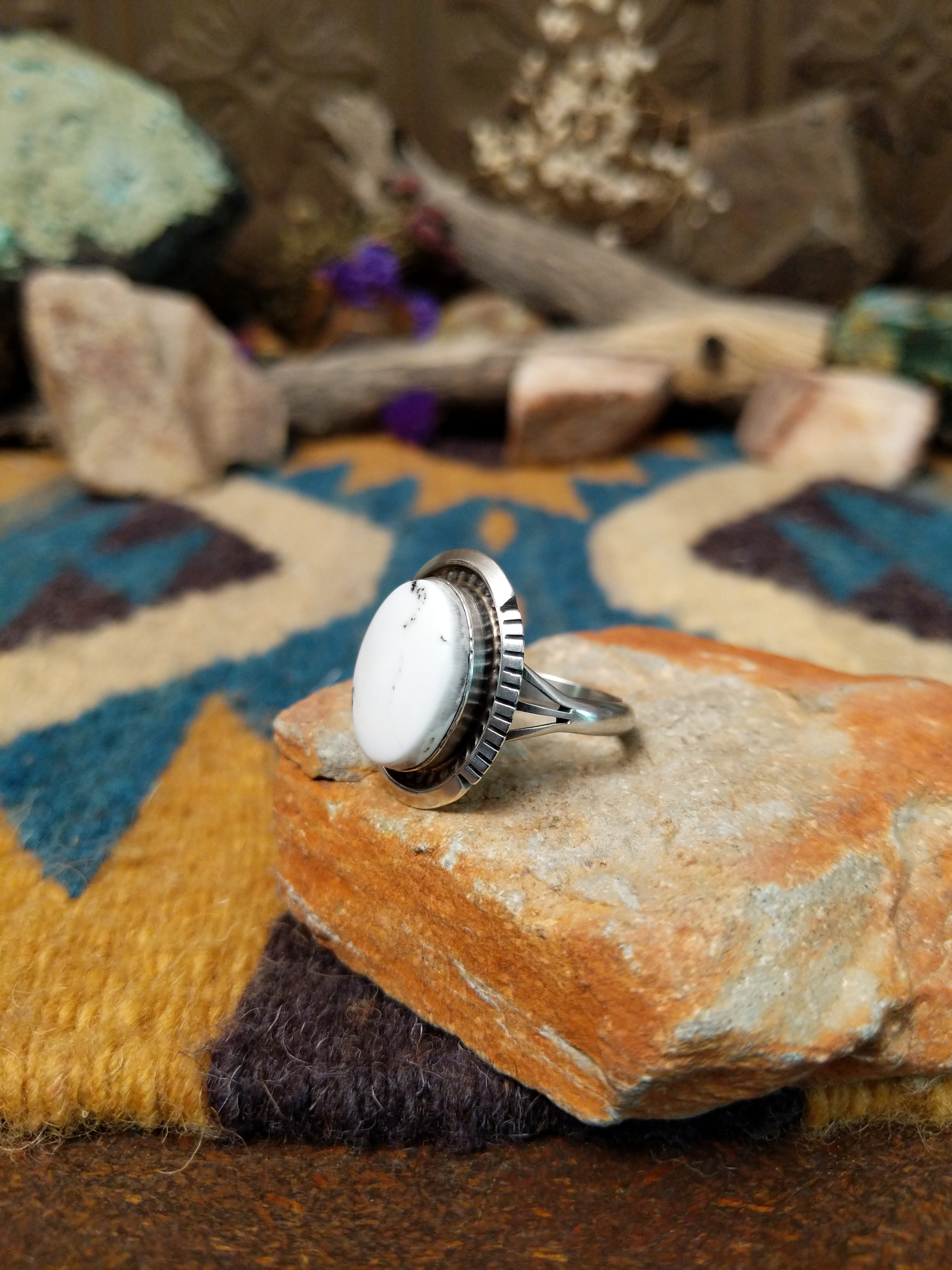 White Buffalo sterling silver ring by Alfred Martinez with an oval white stone and natural black veining; side view.