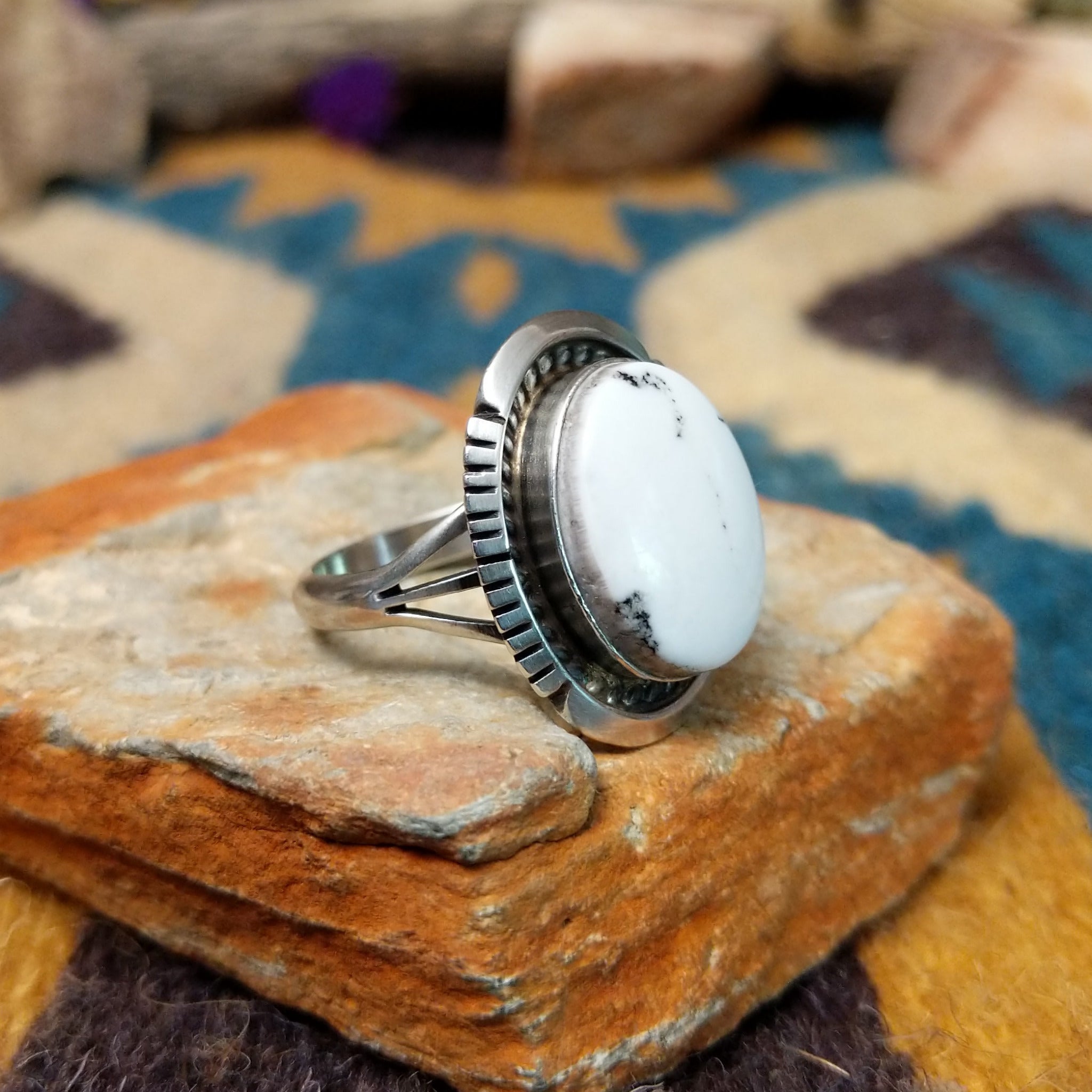 White Buffalo sterling silver ring by Alfred Martinez with an oval white stone and natural black veining; side view.
