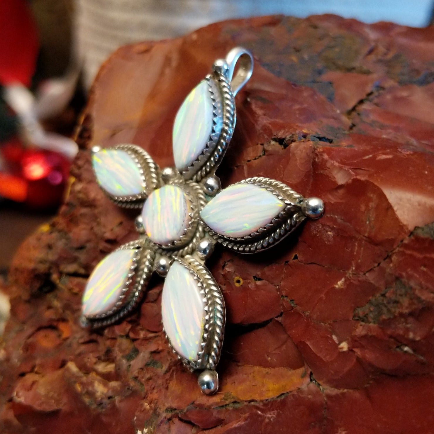 Sterling silver star pendant with manmade opal set in the bezels that are framed by twisted rope accents.