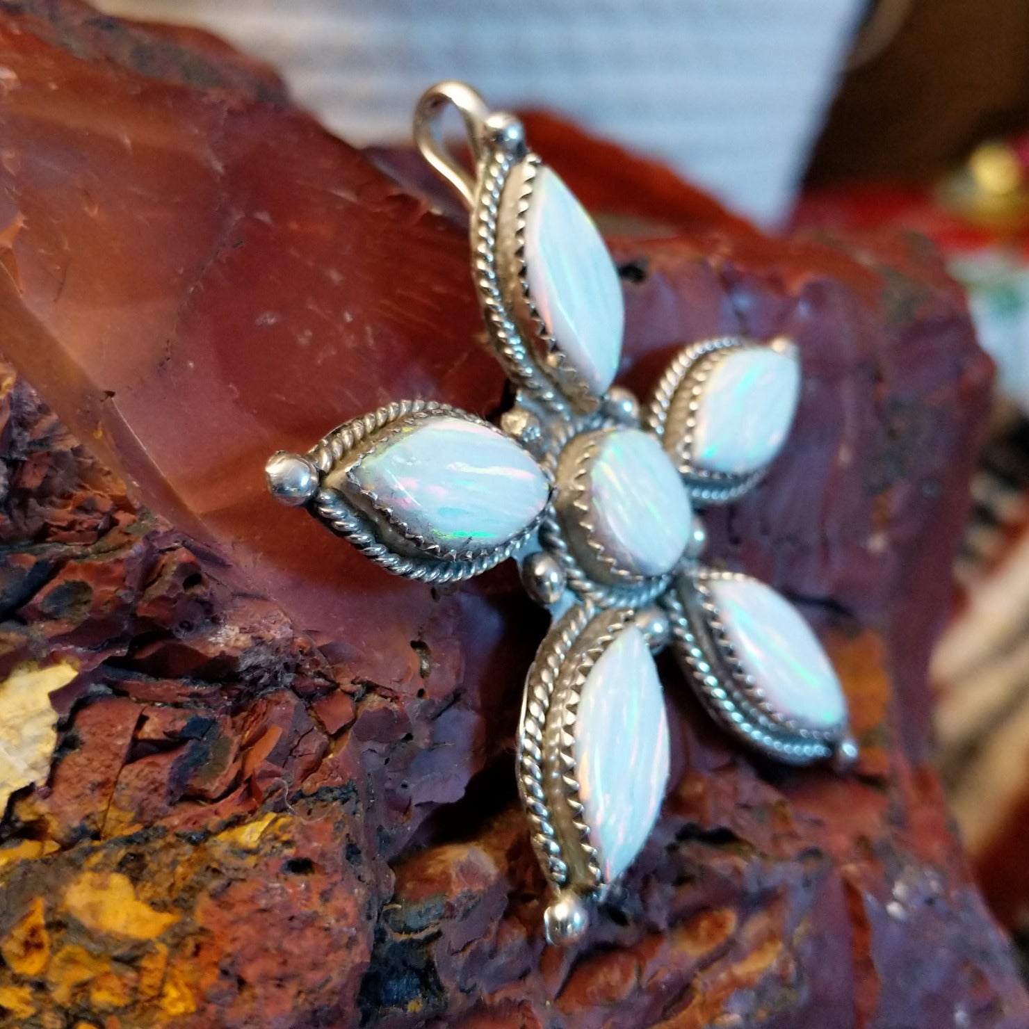 Sterling silver star pendant with manmade opal set in the bezels that are framed by twisted rope accents.