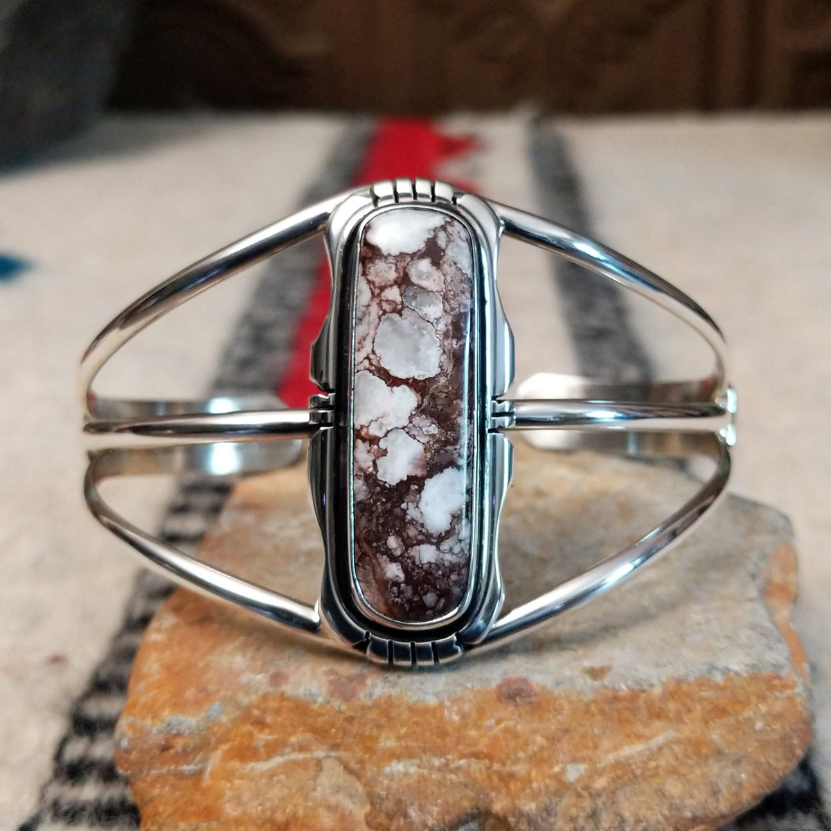 Silver cuff by Amory Begay featuring a long rectangular Wild Horse stone with creamy white and brown matrix, framed by polished silver and curved split bands.