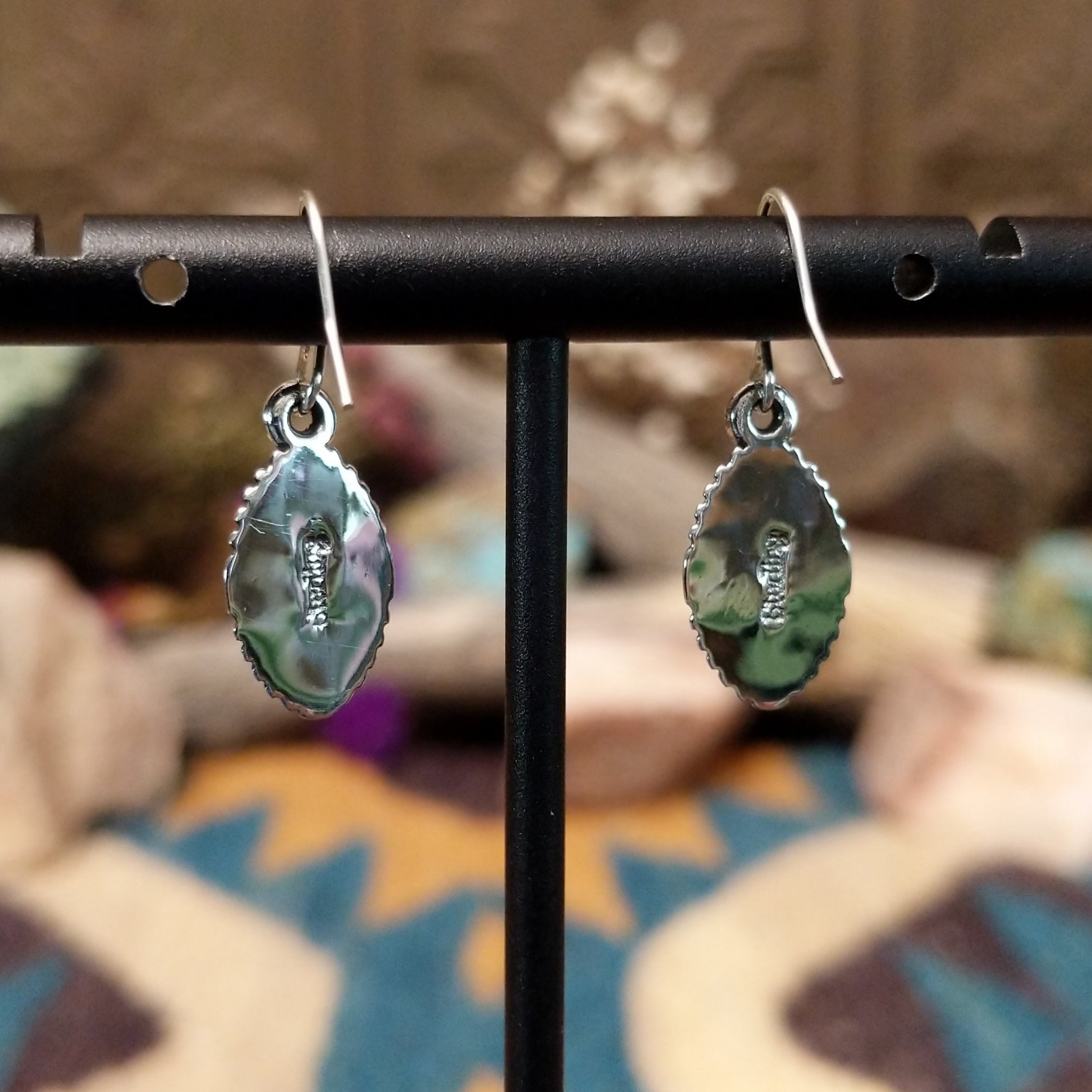 Handcrafted sterling silver navette earrings featuring natural Wild Horse stone with creamy white and rich brown patterns, accented by detailed silver beadwork and French hook ear wires; artisan and Sterling Silver stamp.
