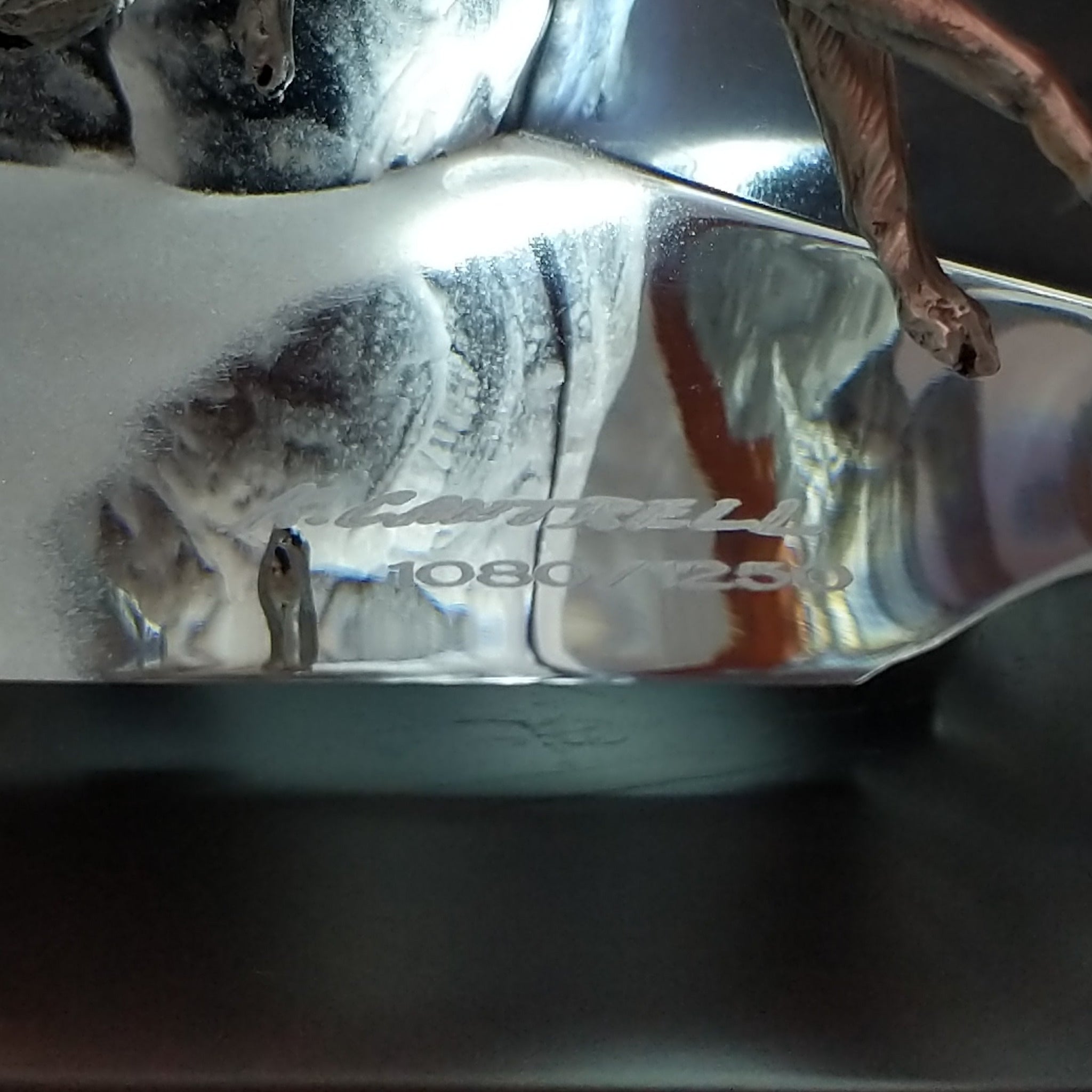 A frosted Lucite sculpture shaped like a wolf's head with a hand-painted wolf running inside the clear crystal interior, creating the illusion of movement; artisan signature and production number.
