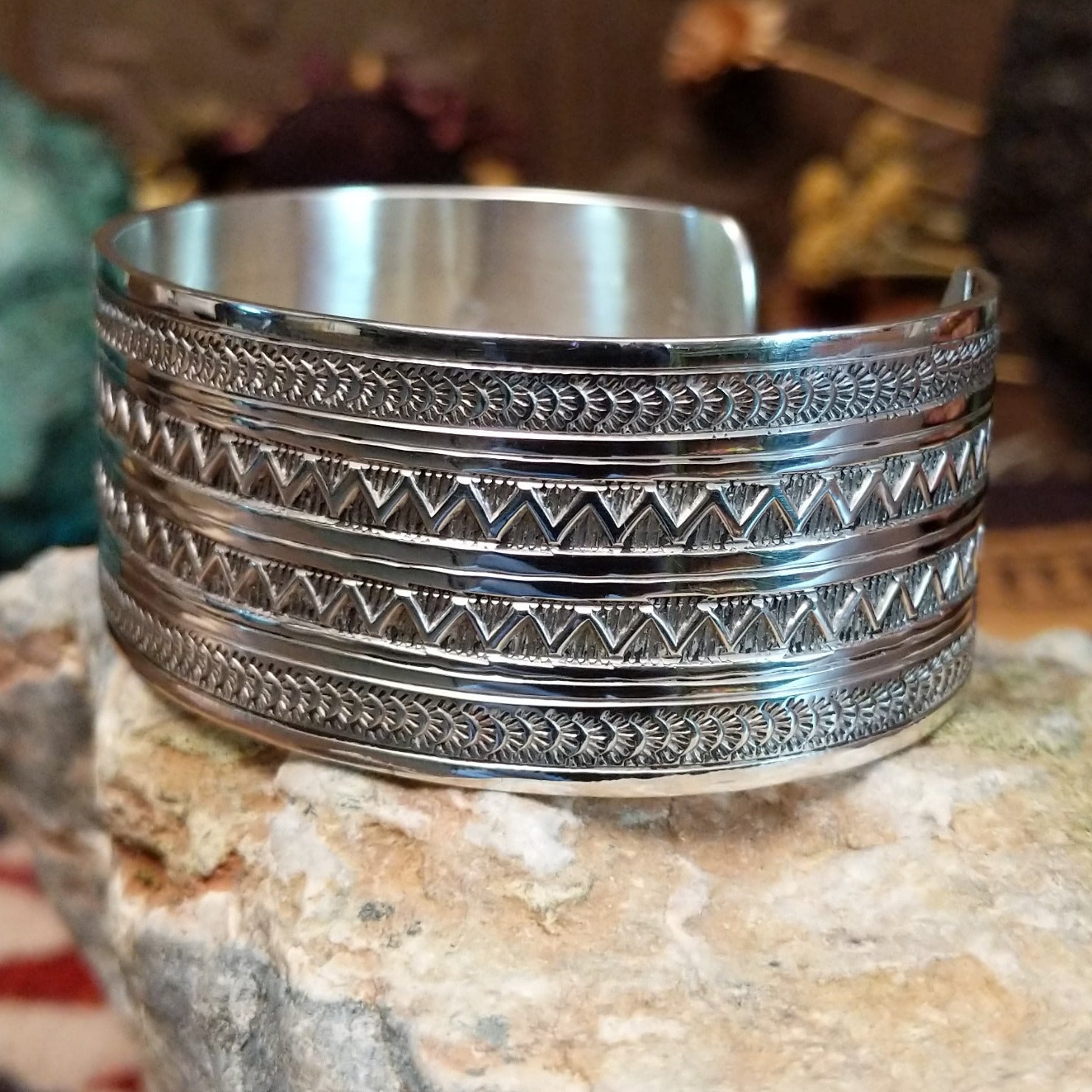 Wide sterling silver cuff bracelet with twin zigzag bands and intricate hand-stamped geometric detailing.