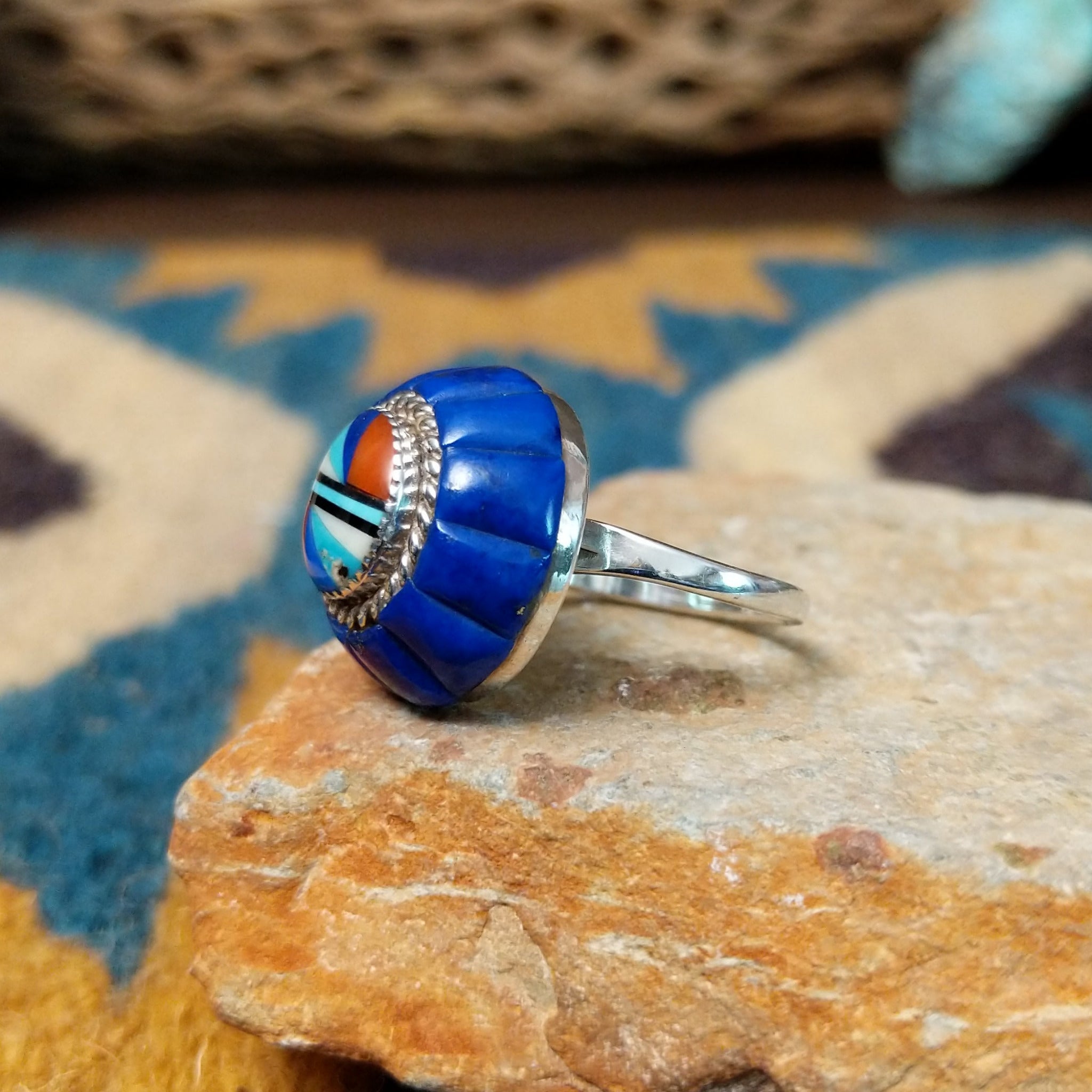 Handcrafted sterling silver Zuni dome ring by Lee & Mary Weebothee, featuring a colorful Sunface-inspired multistone inlay surrounded by lapis; side view.