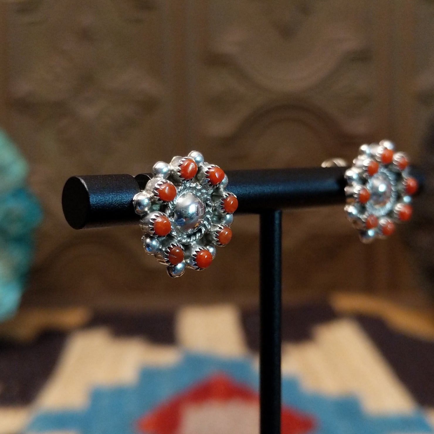 Sterling silver earrings with coral set in notched bezels.
