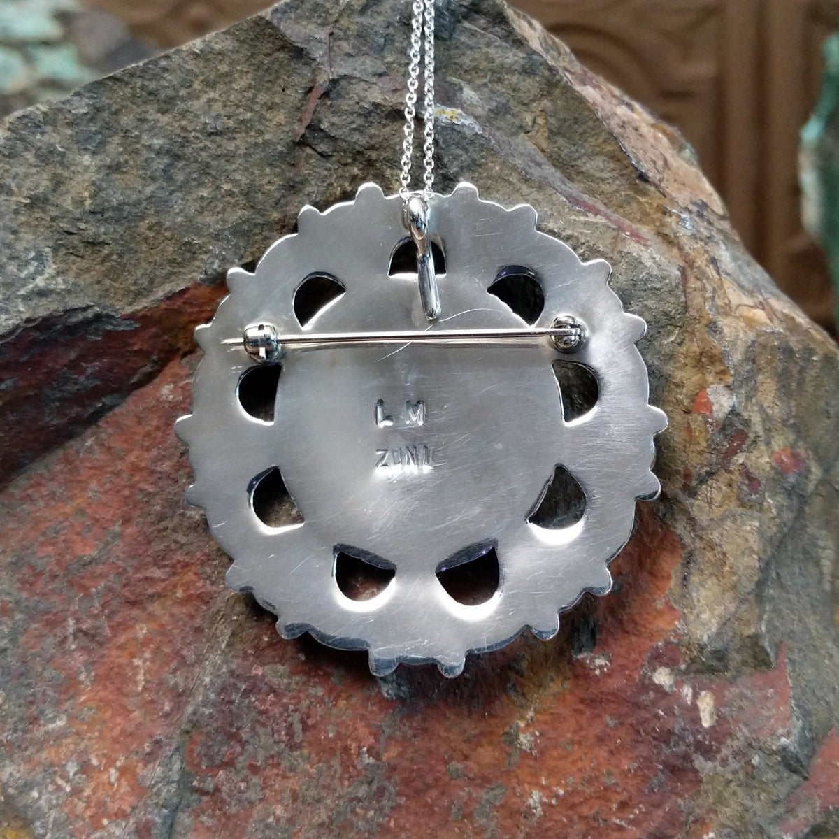 Zuni turquoise pendant and pin by Lorraine Waatsa featuring a floral cluster of turquoise stones surrounded by polished silver loops, twisted wire, and silver bead detailing; artisan and tribe stamp.