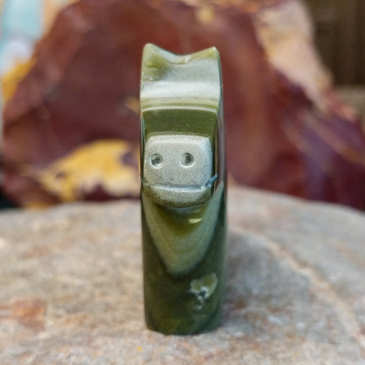 Ricolite carved into a horse fetish with green banding and etched details.