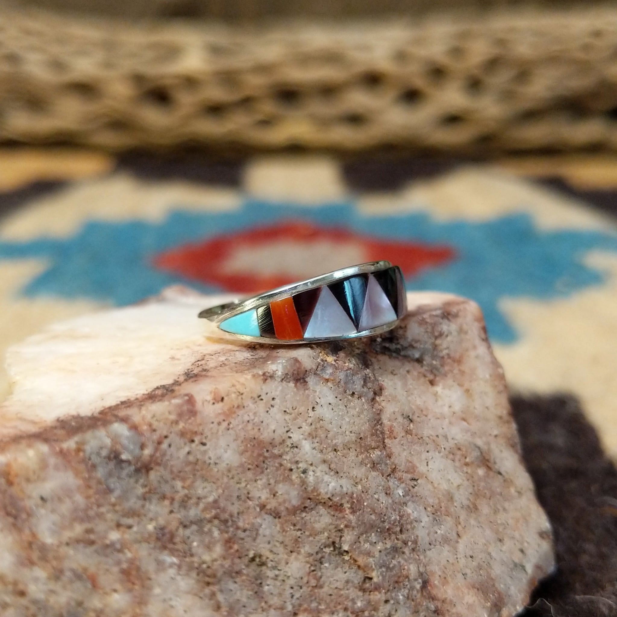 Zuni inlay ring by Tammie Qualo, featuring precisely fitted natural stones set in a handcrafted sterling silver band with traditional Zuni craftsmanship. Side view.