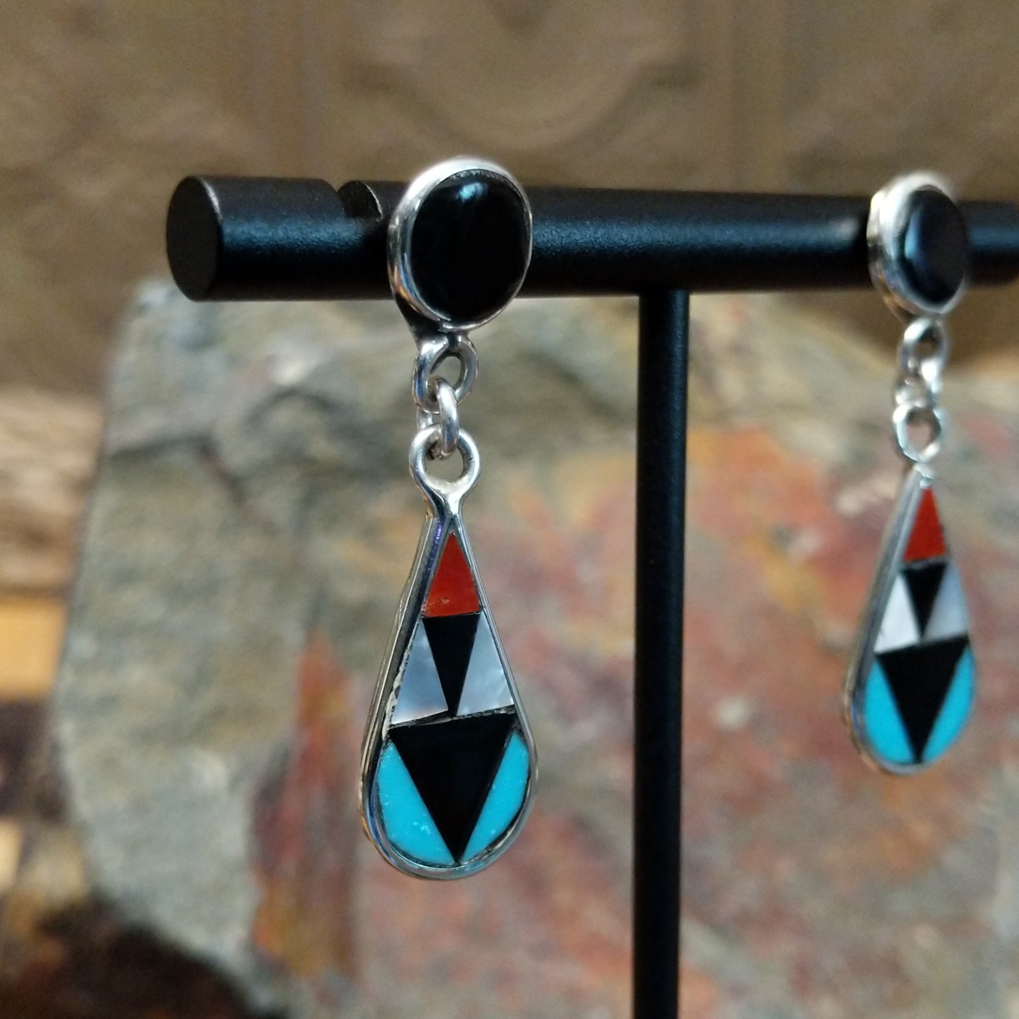 Handcrafted sterling silver Zuni inlay teardrop earrings by Florencia Lucio, featuring colorful multistone inlay in a classic teardrop design; side view.