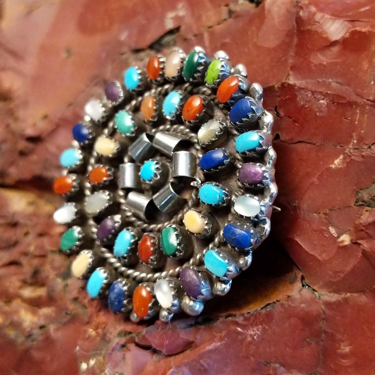 Round multi-stone pendant with vibrant colors and twisted rope accents.