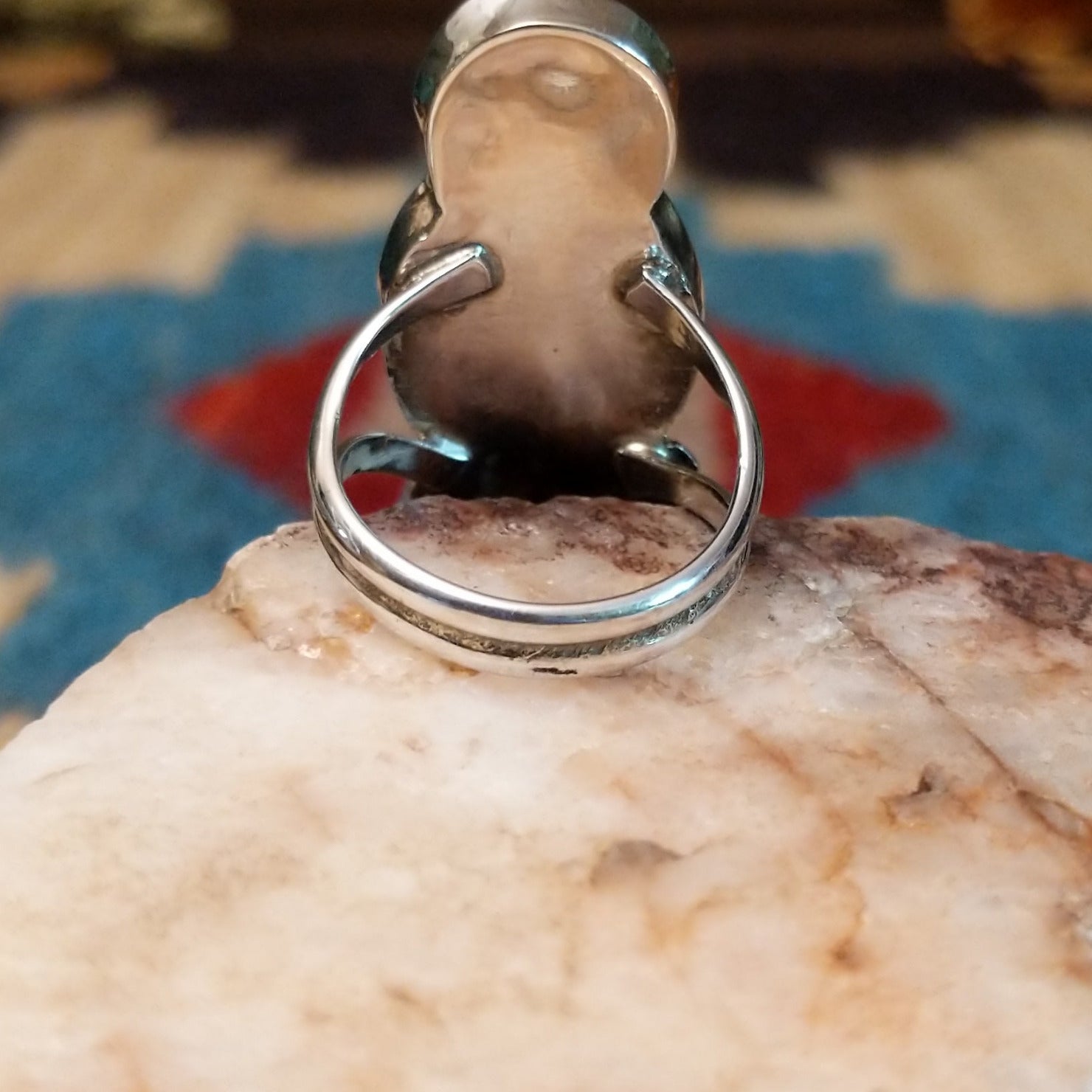 Sterling silver ring with maiden motif featuring turquoise, black onyx, coral, and mother of pearl.