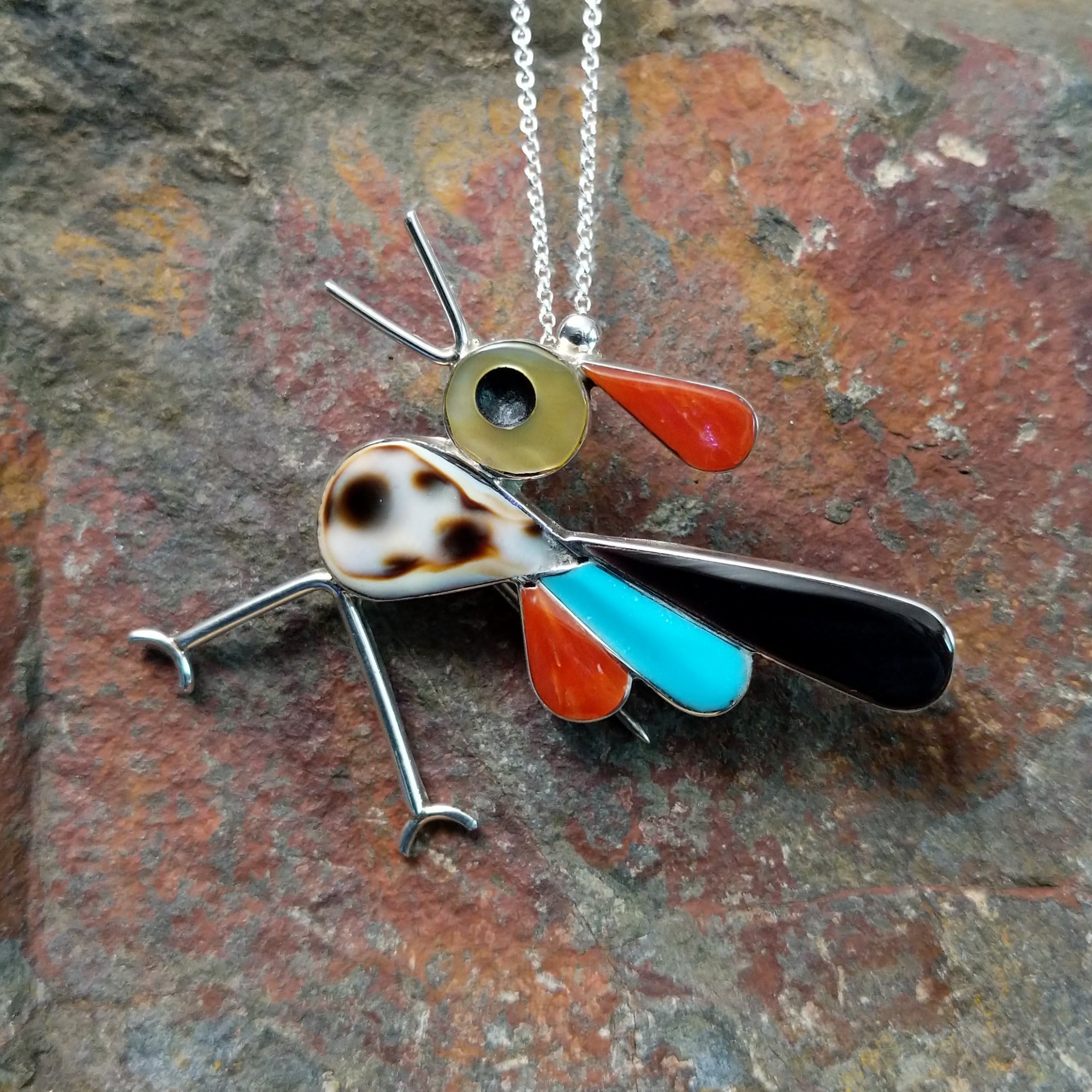 Handcrafted sterling silver multistone roadrunner pin and pendant by K.E., featuring traditional Zuni stone inlay in a colorful bird design.