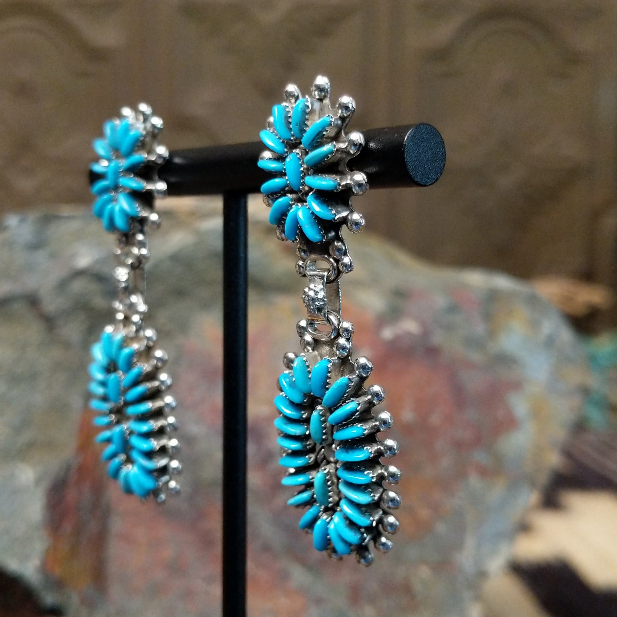 Handcrafted sterling silver Zuni needlepoint turquoise concho earrings by Connie Wyaco, featuring a two-piece dangle design with vibrant turquoise needlepoint; side view.