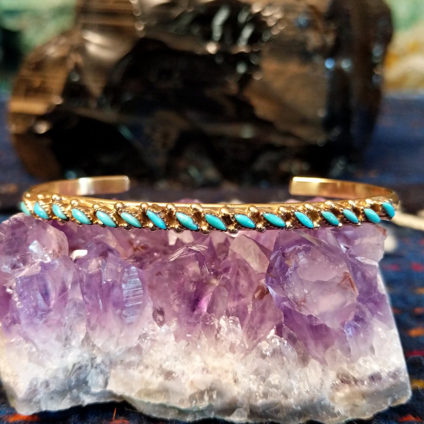 Zuni needlepoint turquoise cuff featuring the intricate design and gold beading.