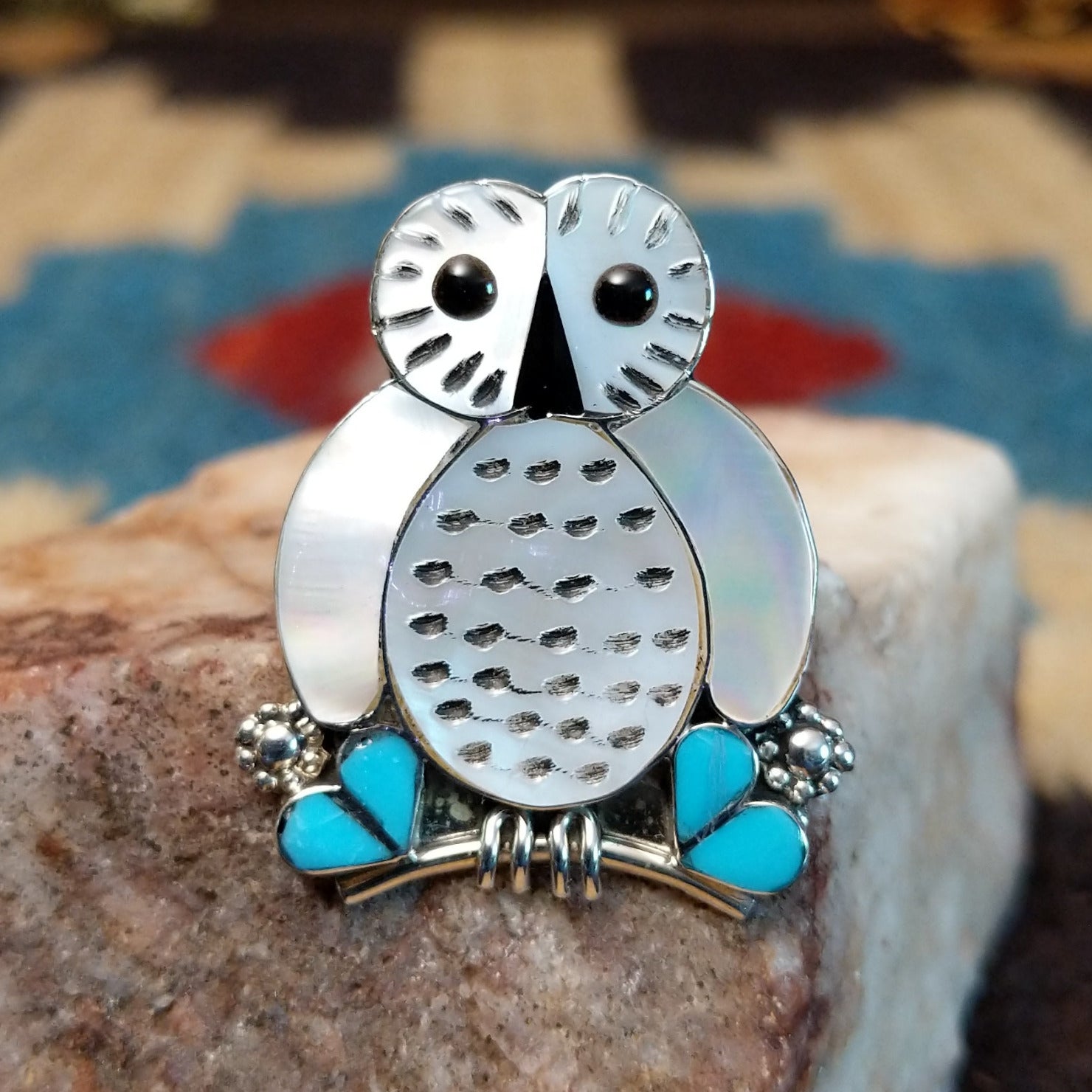 Sterling silver ring with mother of pearl, turquoise, and black onyx inlaid to create the owl motif.