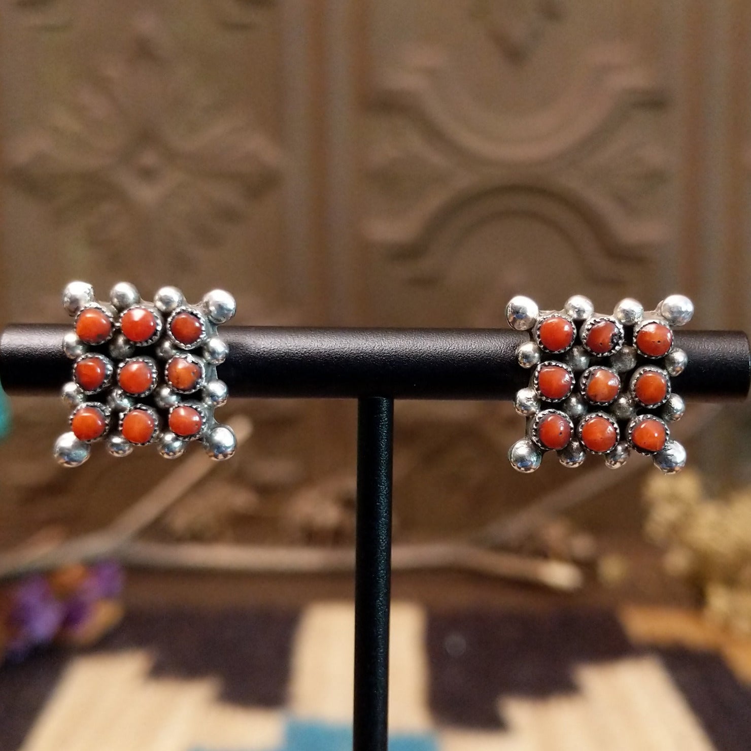 Sterling silver earrings with coral set in notched bezels, arranged in a square formation.