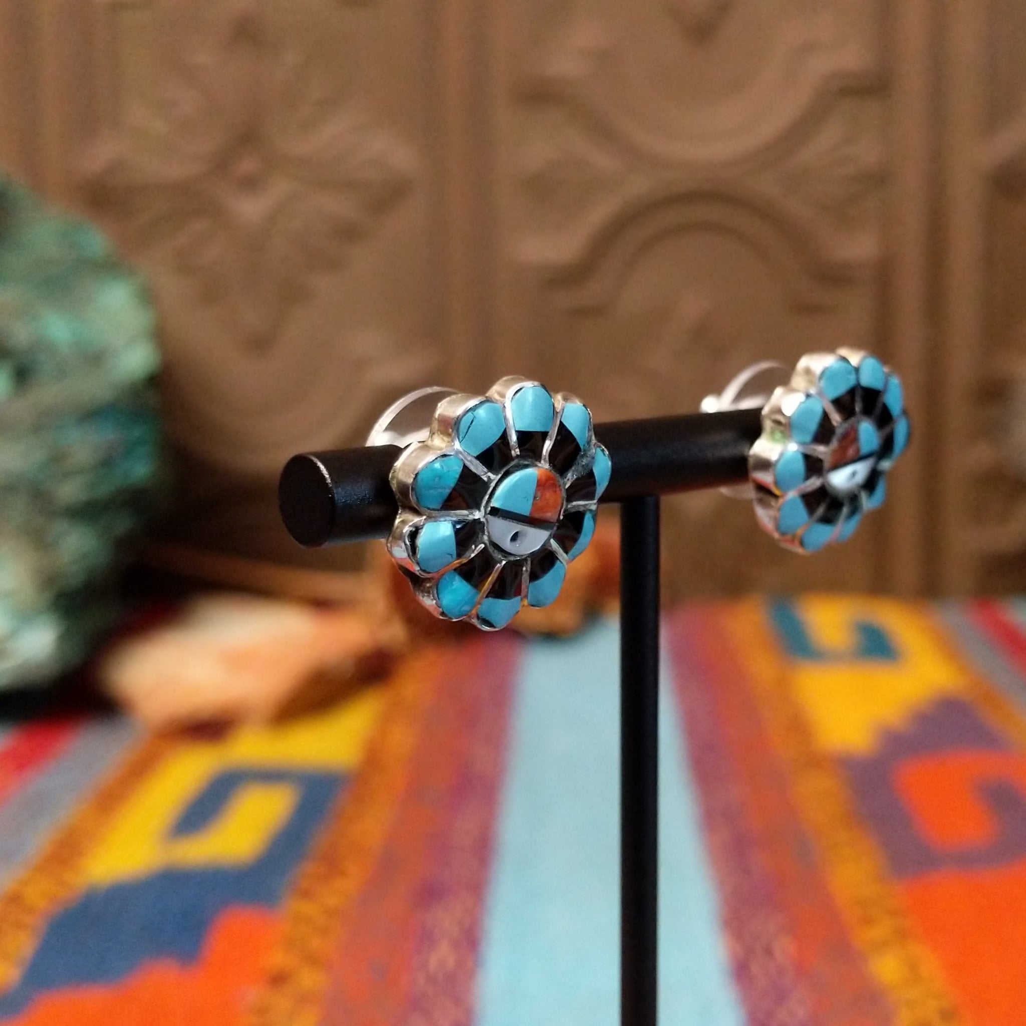 Zuni Sunface Sterling Silver earrings by Marisa Selecion, featuring turquoise, coral, black onyx, and mother of pearl, with detailed Sunface designs; side view.