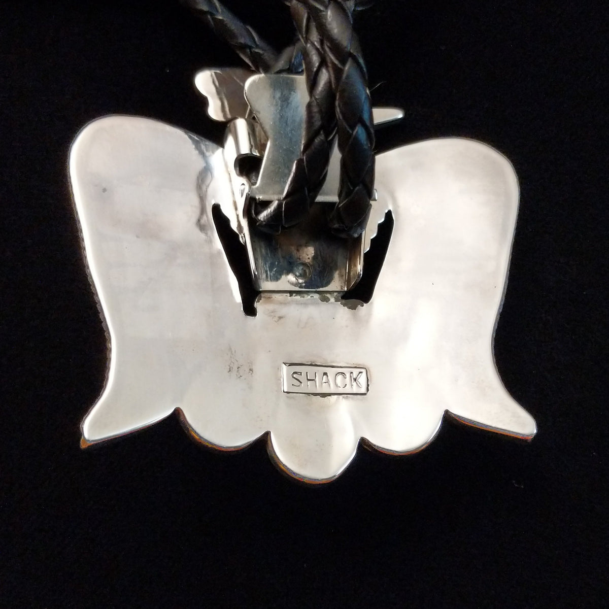 Zuni Thunderbird Bolo Tie by Bobby Shack featuring a detailed silver thunderbird with colorful turquoise, coral red, white, and black geometric inlay, outstretched wings, braided black leather cord, and polished silver tips; artist stamp on back.