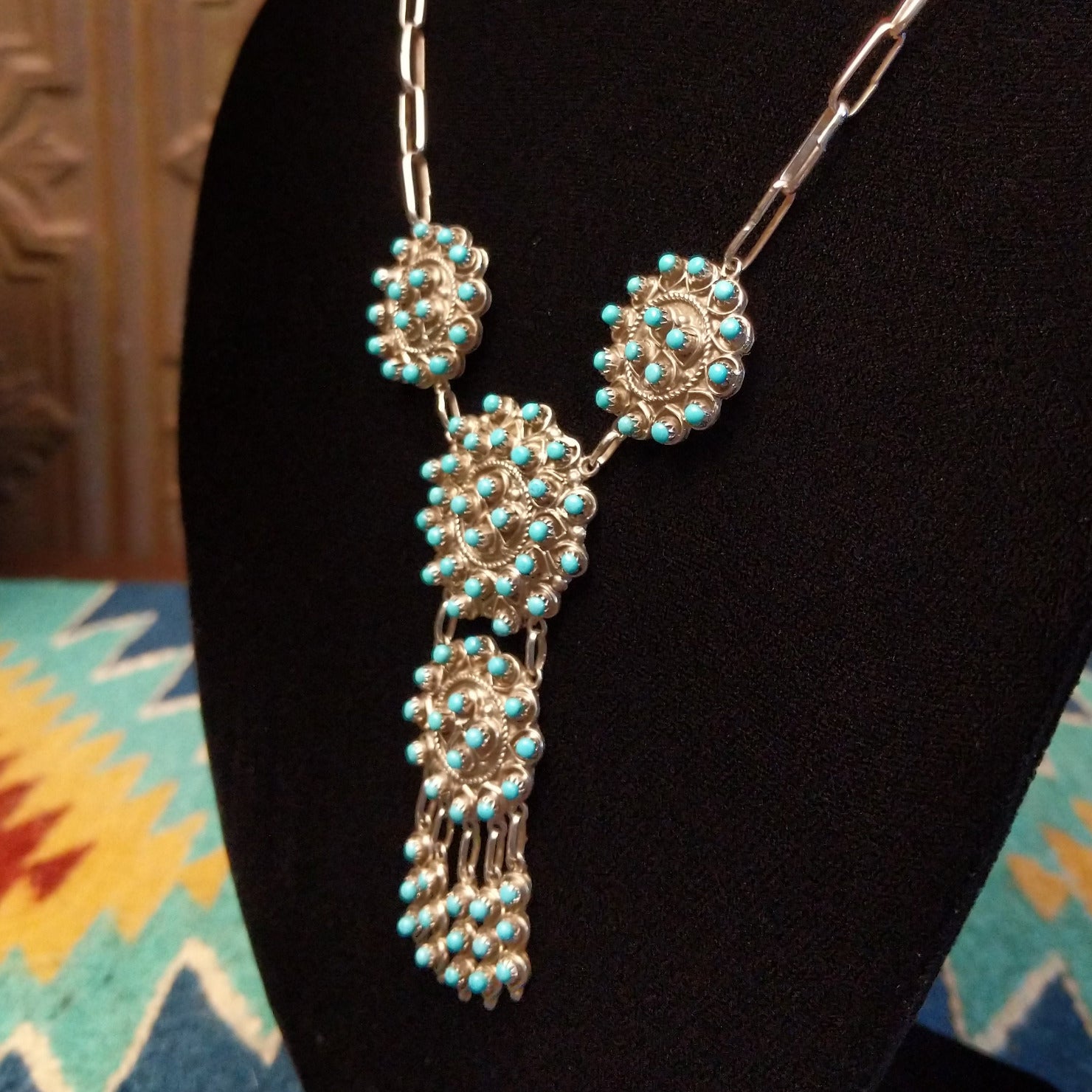 Sterling silver link necklace with drop cluster pendants and turquoise set in notched bezels.