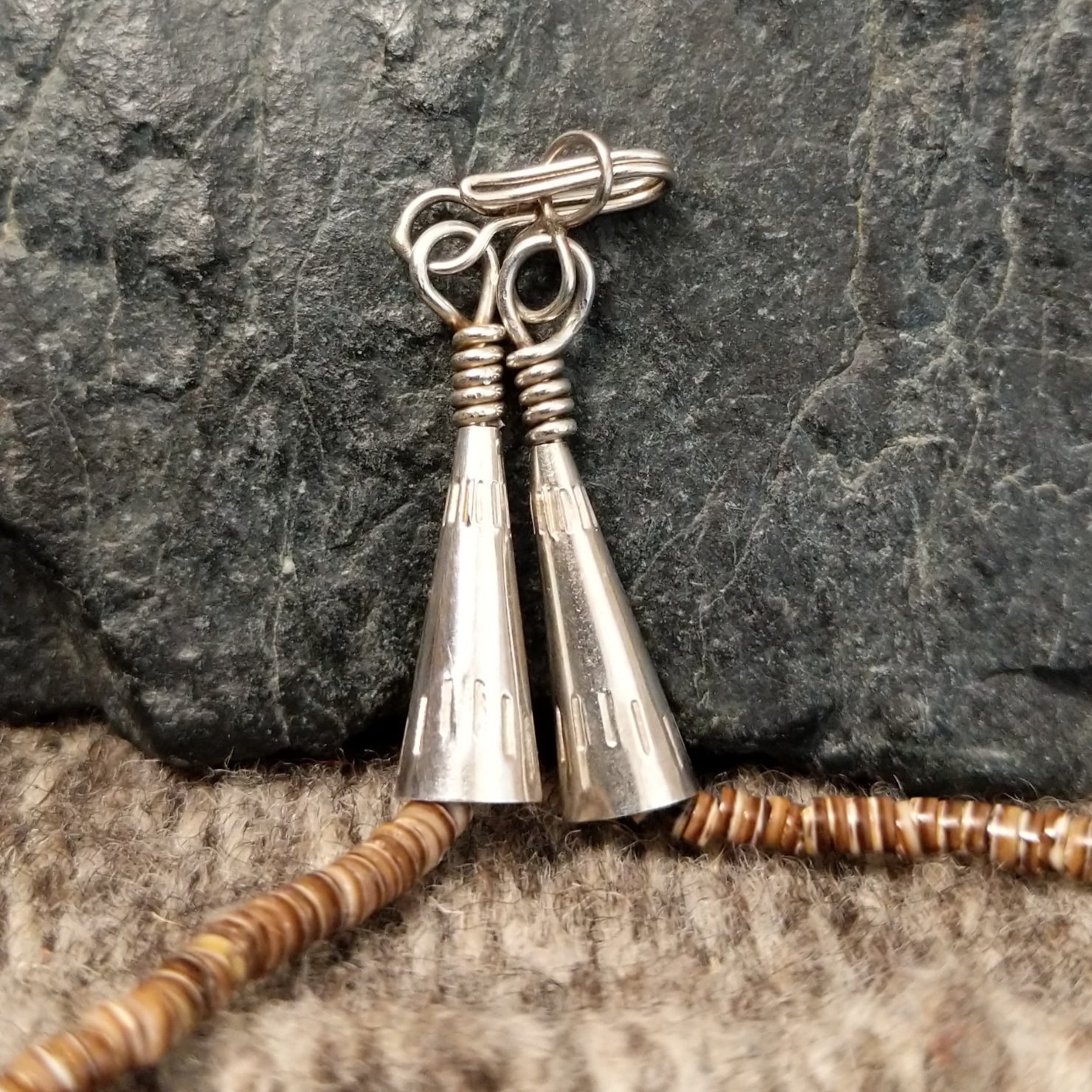 The sterling silver clasp and artist details etched into the silver.