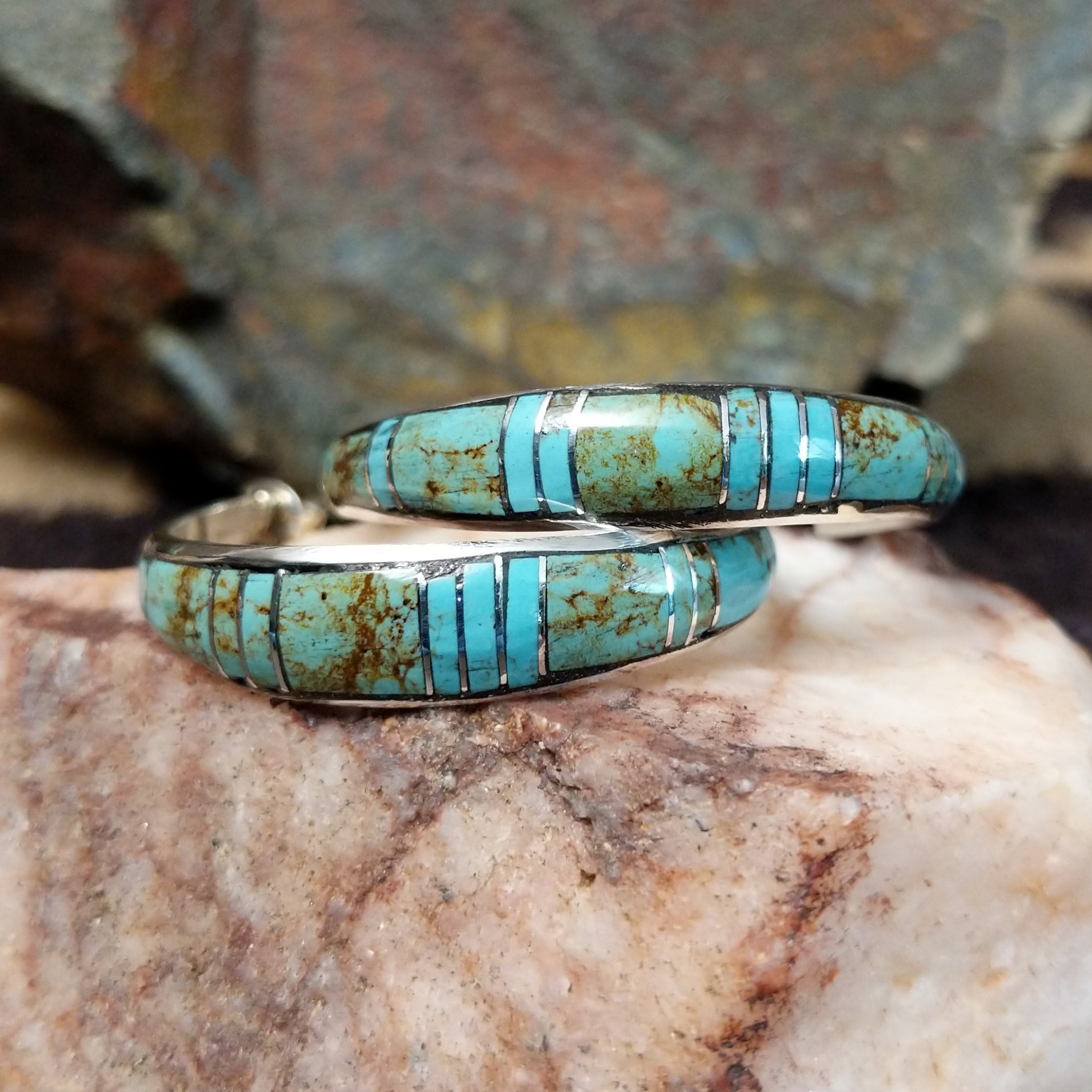 Handcrafted sterling silver Zuni turquoise hoop earrings by Keme Peina, featuring turquoise channel inlay with geometric accents.
