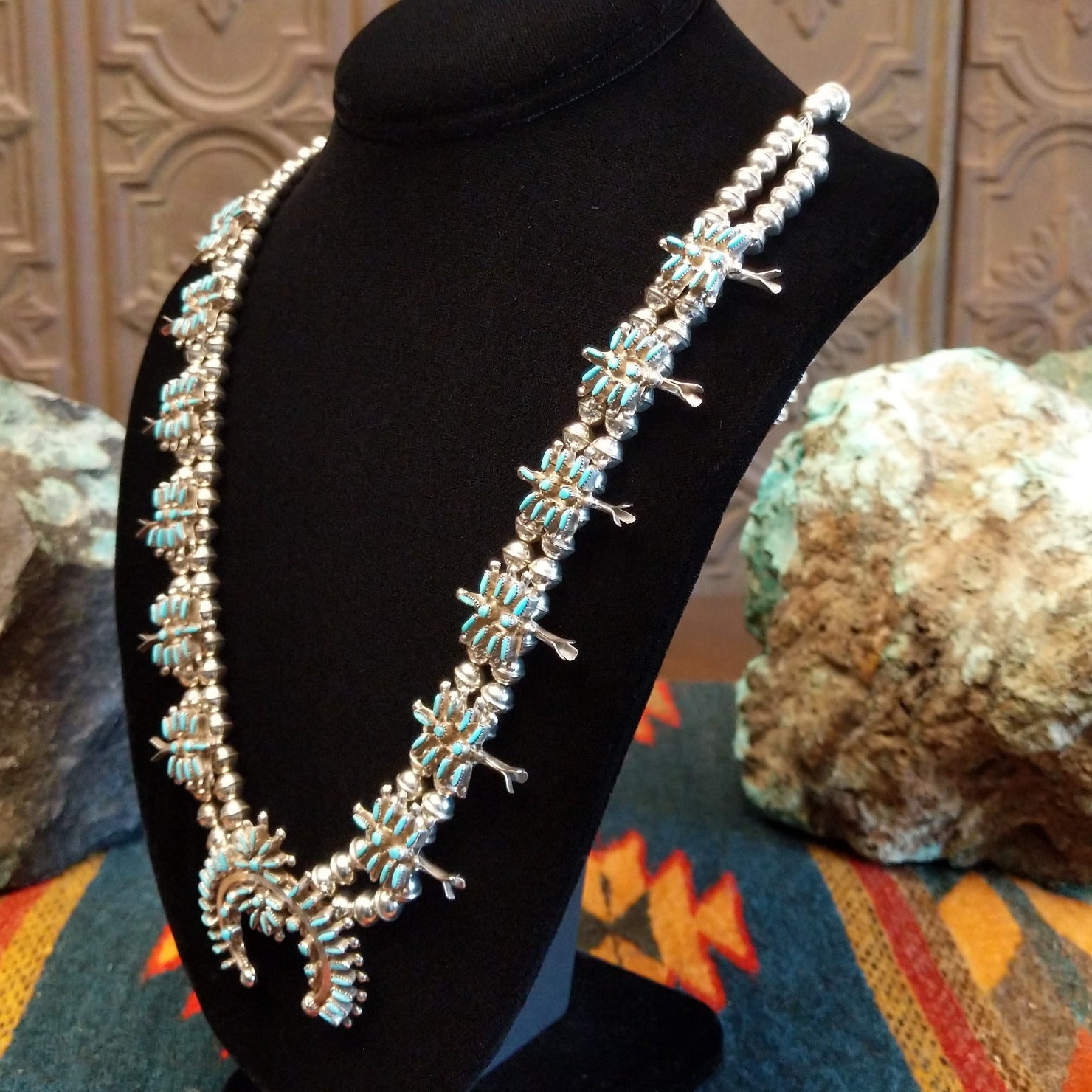 Sterling silver squash blossom naja necklace with turquoise set in individual bezels.