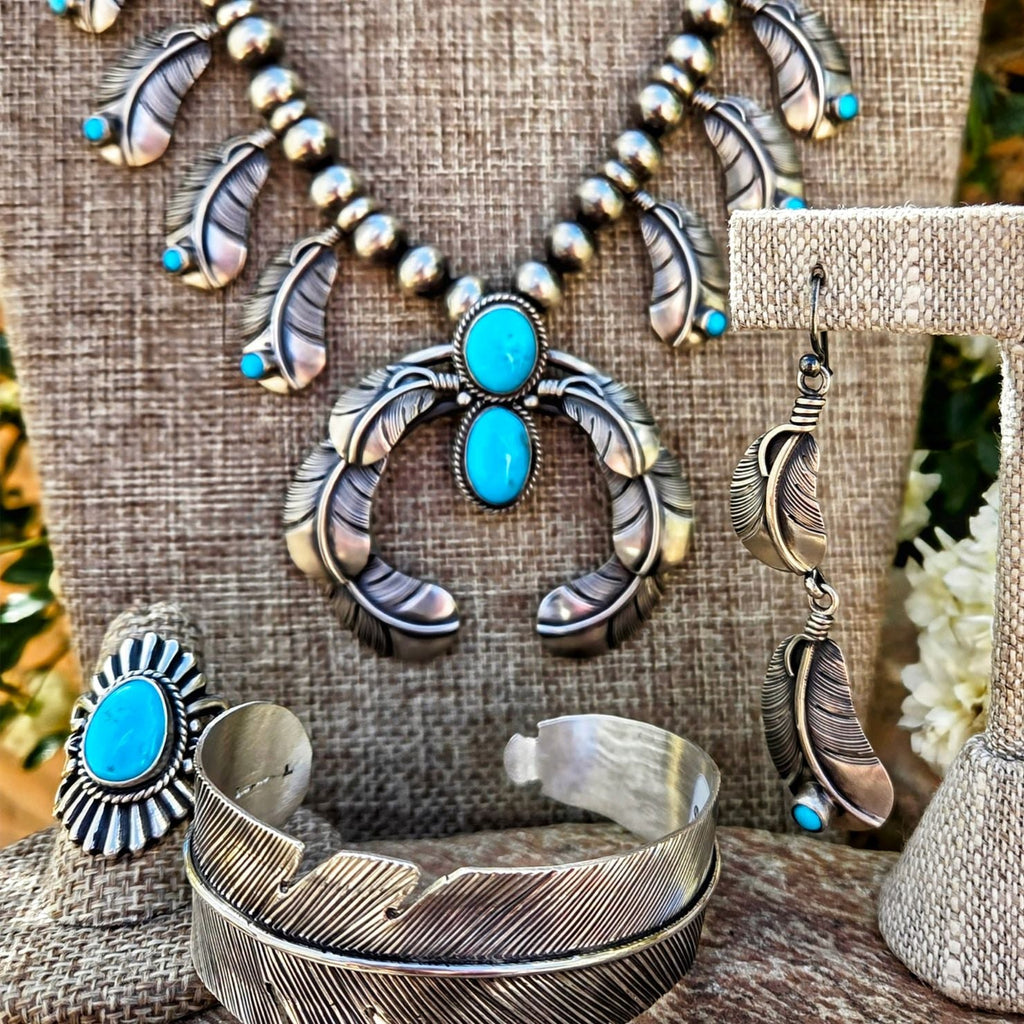 Alt-text: Authentic Native American made jewelry featuring sterling silver and turquoise, including a necklace, bracelet, ring, and earrings, displayed at Arlene’s store in Tombstone, AZ.