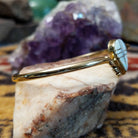 14k gold cuff by Hyson Craig with teardrop opal inlay and geometric gold channels.