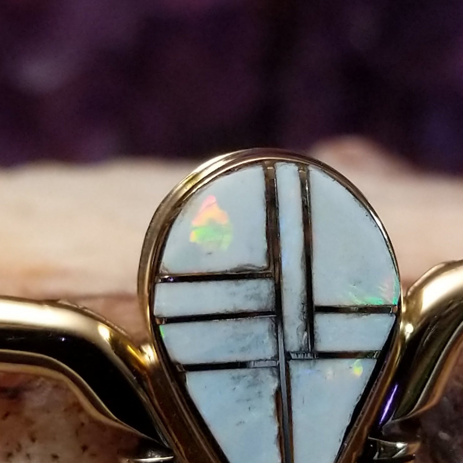 Close up of teardrop opal inlay with geometric 14kt gold channels.