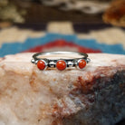 Sterling silver ring with coral set in three small, round bezels.