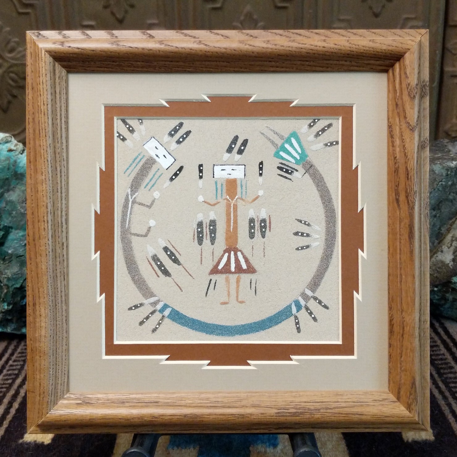Framed Navajo sand painting of a Rainbow Yei within a rainbow arc.