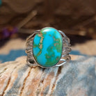 Sterling silver ring with Sonoran gold turquoise set in an oval bezel and band with strands of silver.
