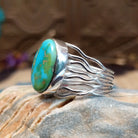 Sterling silver ring with Sonoran gold turquoise set in an oval bezel and band with strands of silver.