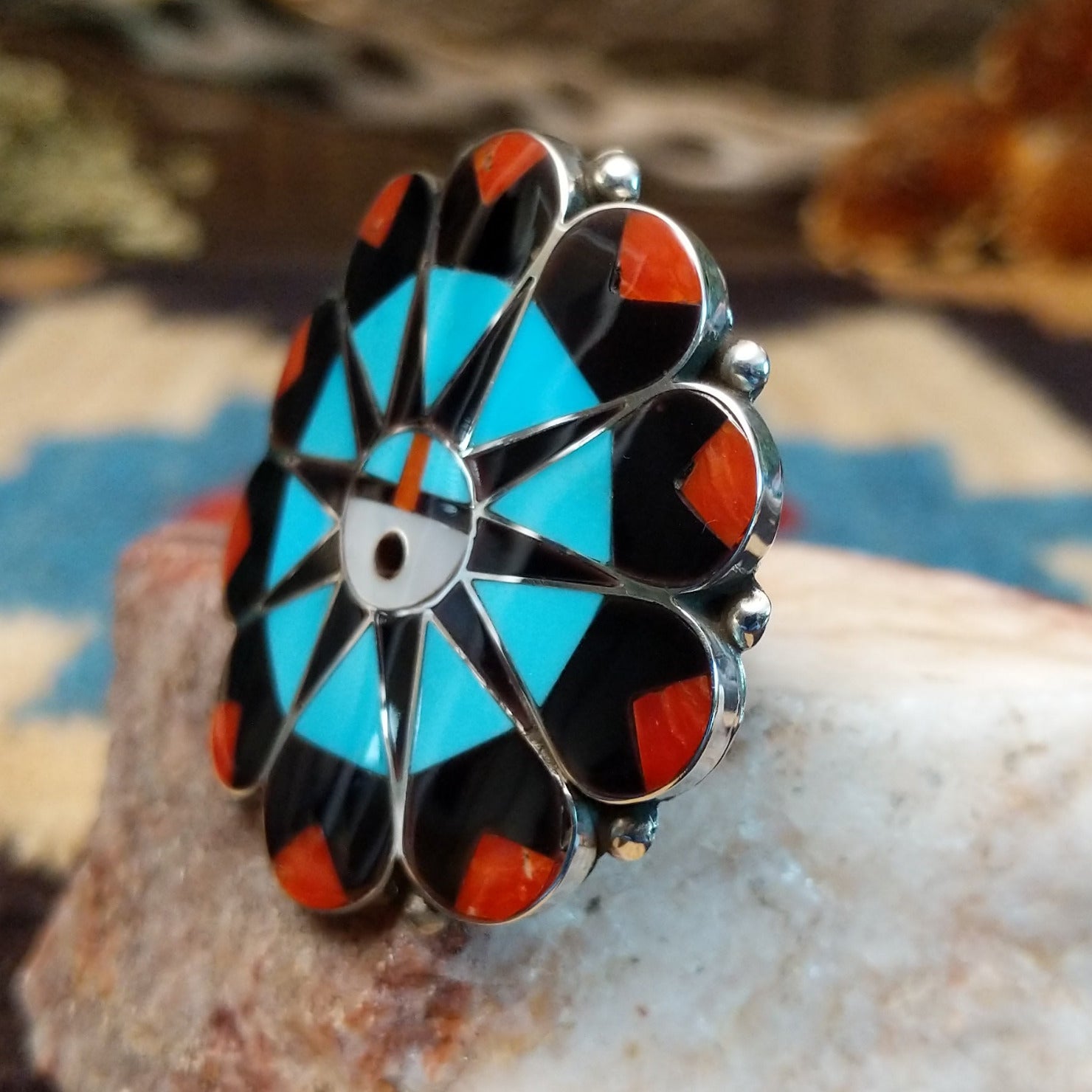 Sterling silver ring with multistone inlay creating a sunface motif.