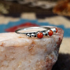 Sterling silver ring with coral set in three small, round bezels.