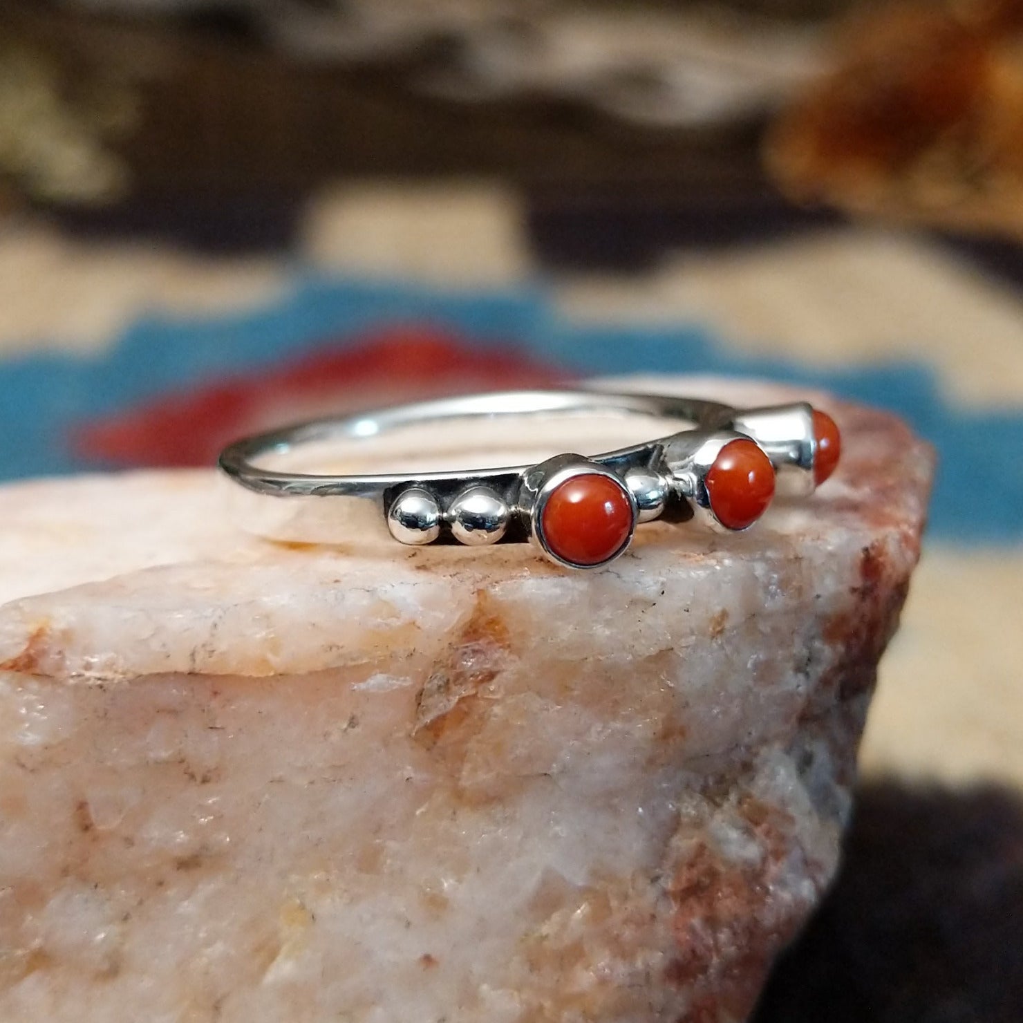 Sterling silver ring with coral set in three small, round bezels.