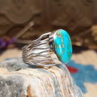 Sterling silver ring with Sonoran gold turquoise set in an oval bezel and band with strands of silver.