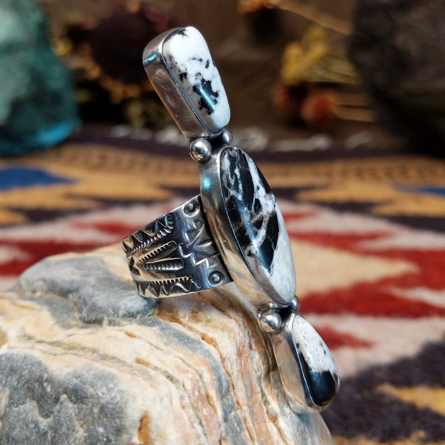 Handcrafted sterling silver ring by Bernyse Chavez featuring an elongated White Buffalo stone with natural black-and-white patterns in a Southwestern Native American design.  Side view.