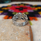Malachite ring by Angela Martin with an oval banded stone and multi-strand wavy silver band.