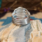 Sterling silver ring with Sonoran gold turquoise set in an oval bezel and band with strands of silver.