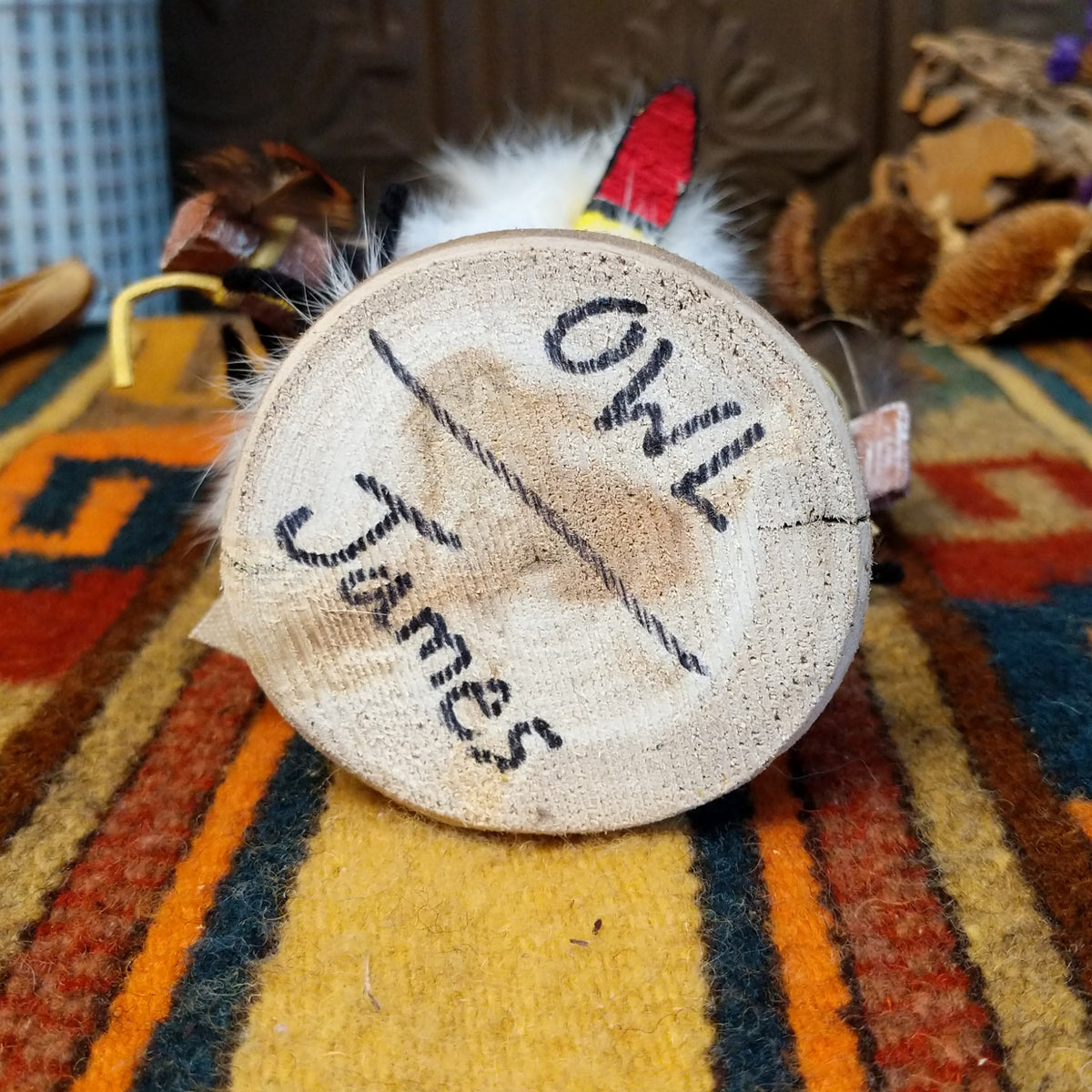 Underside of Navajo Owl Kachina doll base with handwritten figure name and artist surname.